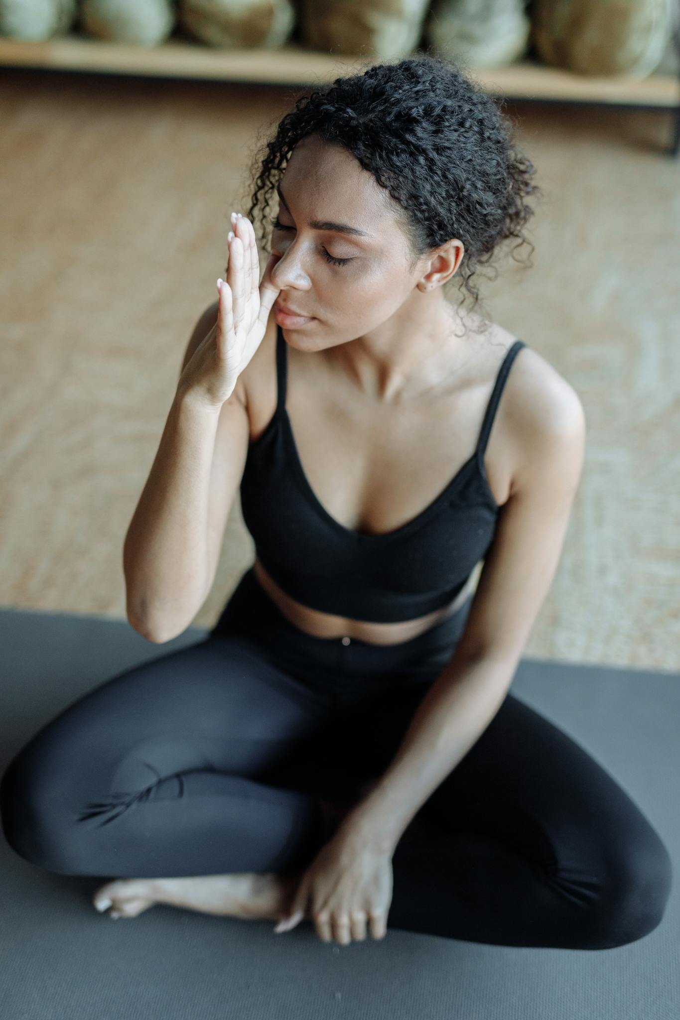 A woman practicing yoga indoors, focusing on mindfulness and relaxation.