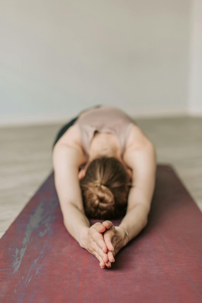 A woman stretches in Child's Pose during a yoga session, promoting wellness and relaxation.
